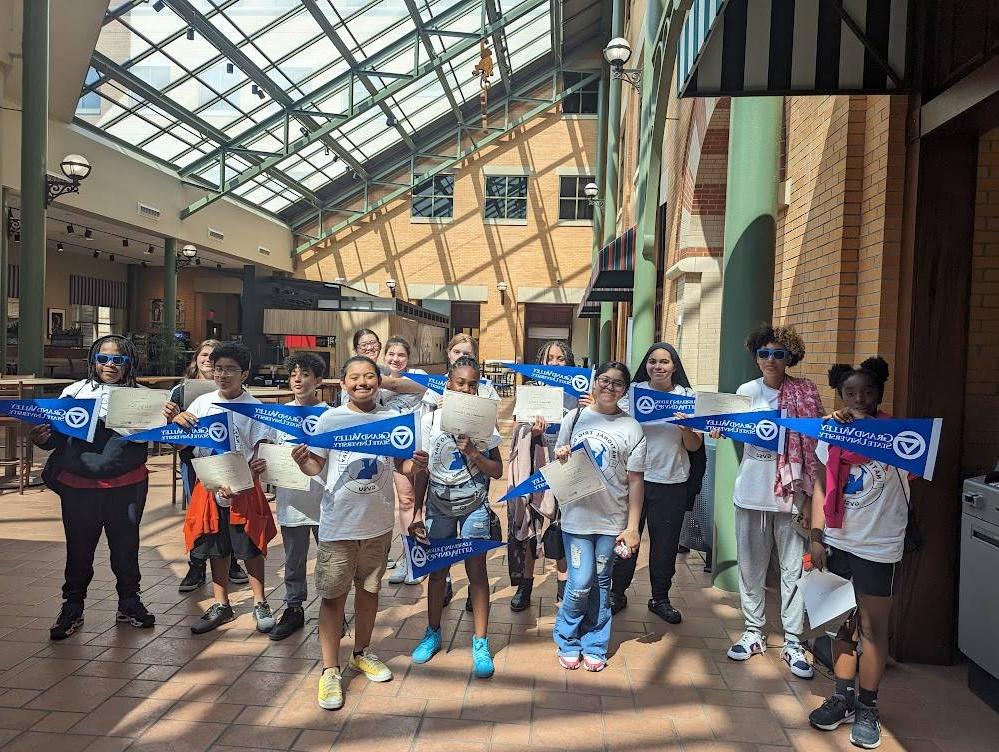 TRIO ETS students holding GVSU pennants